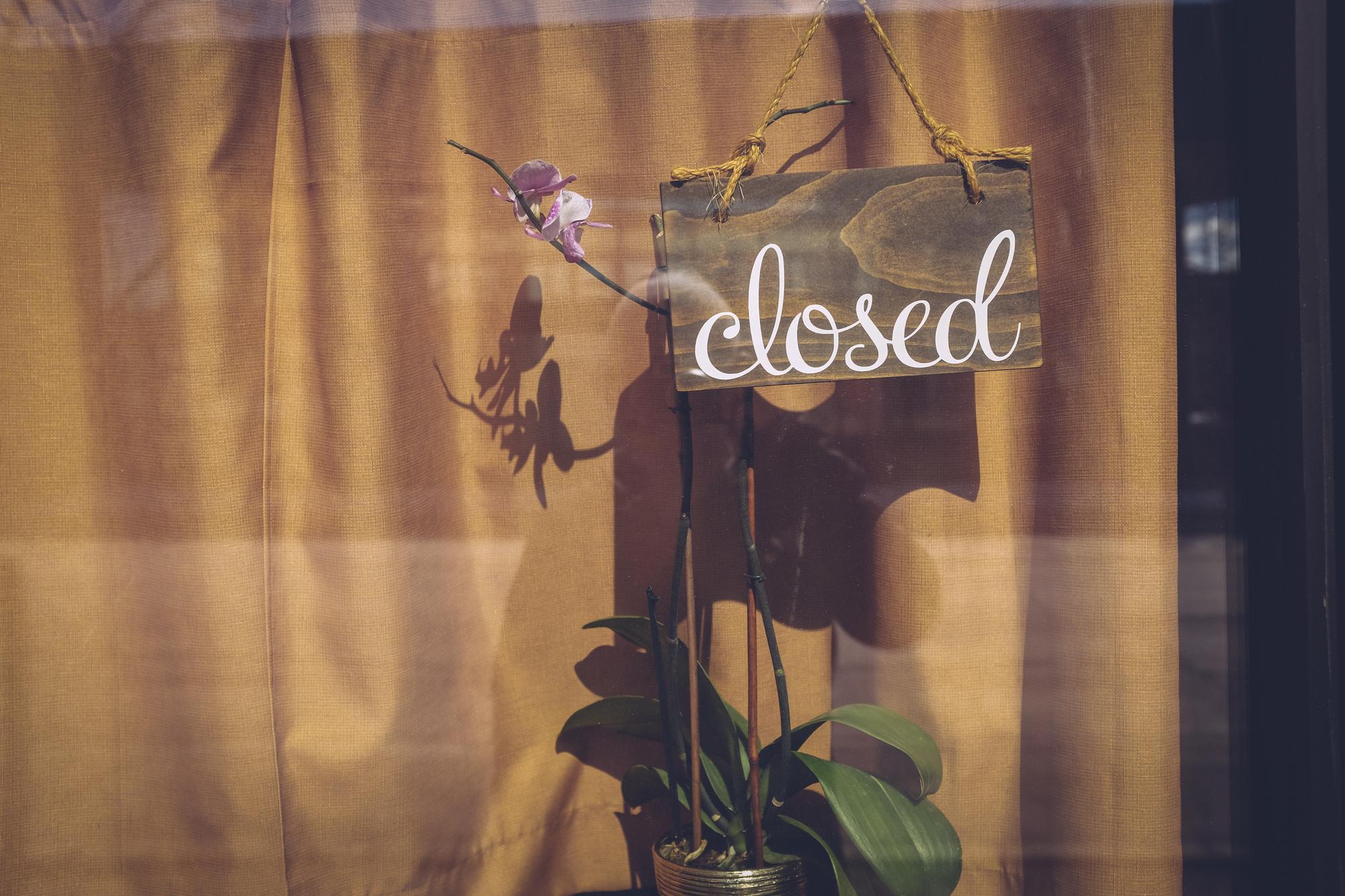 Studio exterior with a small sign and embroidered samples in window